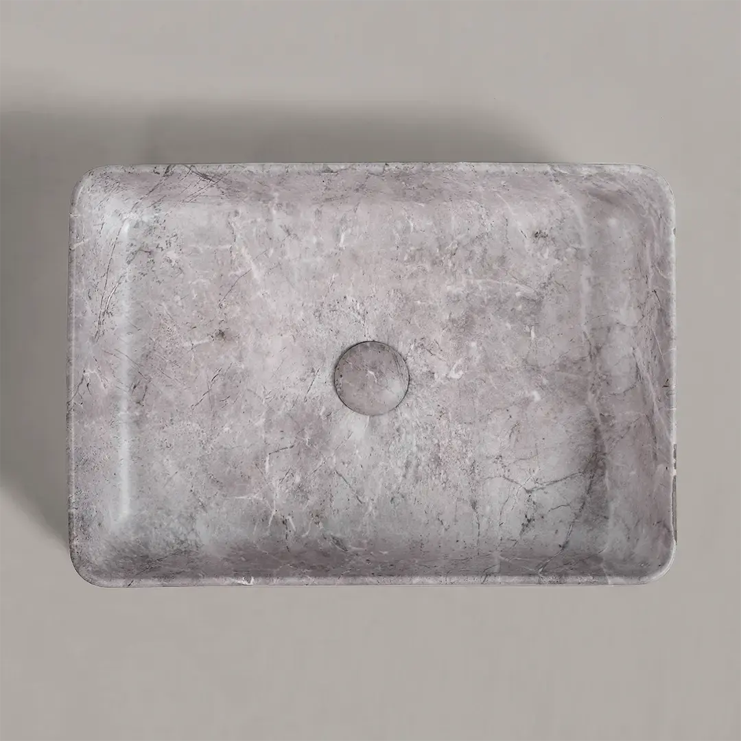 Vasque à poser en céramique grise, finition effet marbre veiné, au design rectangulaire élégant avec bonde assortie intégrée.