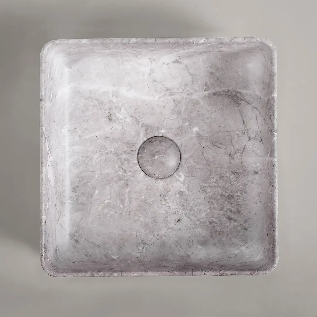 Vasque à poser carrée en céramique avec finition effet marbre gris clair, dotée d’une bonde centrale assortie.
